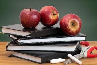 黑板前的桌子上放着四本黑色的书，上面堆着三个苹果. 